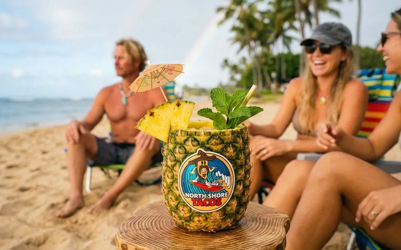 Finished Pineapple Tiki drink in a glass with pineapple wedge, mint, and paper umbrella